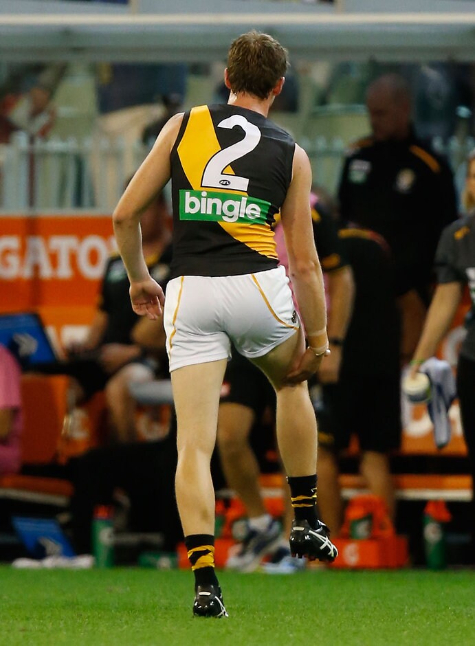 AFL 2016 Rd 02 - Collingwood v Richmond MELBOURNE, AUSTRALIA - APRIL 1: Dylan Grimes of the Tigers reaches for his leg during the 2016 AFL Round 02 match between the Collingwood Magpies and the Richmond Tigers at the Melbourne Cricket Ground, Melbourne on April 1, 2016. (Photo by Michael Willson/AFL Media)